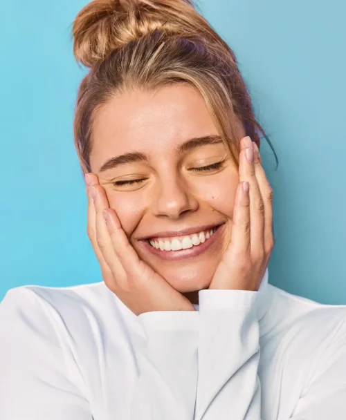 Mulher sorridente com as mãos no rosto